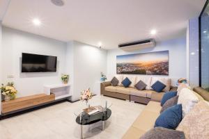 a living room with a couch and a tv at Sita Krabi Hotel in Krabi