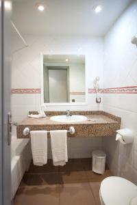 a bathroom with a sink and a mirror and a toilet at Hotel Cassandra in El Arenal