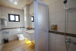 a bathroom with a shower and a toilet and a sink at Heaven Bird B&B in Nanzhuang
