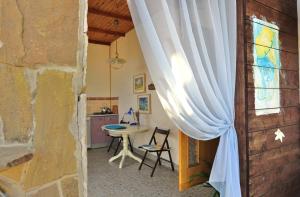a room with a window and a table with chairs at Dom Pod Zvezdopadom Guest House in Koktebel