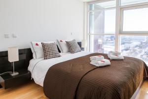 a bedroom with a large bed with towels on it at RENT4REST LISBON PARQUE DAS NAÇÕES 17Th FLOOR RIVER VIEW in Lisbon