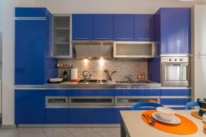 a kitchen with blue cabinets and a table at Park House Niguarda in Milan