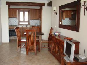una cucina con tavolo, sedie e TV di CARABEO 70 MENYBER a Nerja