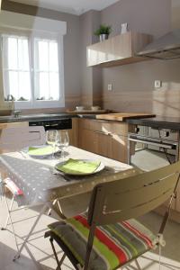 - une cuisine avec une table et des verres à vin dans l'établissement La Tonnelle, à Hardelot-Plage