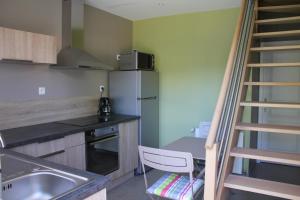 a kitchen with a staircase leading up to a refrigerator at La Tonnelle in Hardelot-Plage
