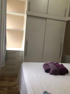 1 dormitorio con 1 cama y 2 toallas púrpuras en Studio Luxo em Copacabana, en Río de Janeiro