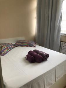 Una cama con tres toallas moradas encima. en Studio Luxo em Copacabana, en Río de Janeiro