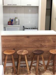 cocina con encimera con 3 taburetes de madera en Studio Luxo em Copacabana, en Río de Janeiro
