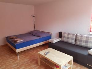 エッテンハイムにあるFerienwohnung Katharinaのベッド1台とソファが備わる小さな客室です。