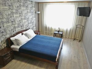 トゥーラにあるInndays on Lunacharskogo-3のベッドルーム1室(青い掛け布団、窓付)