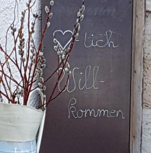 a chalkboard sign with a vase with a plant at Zweite Heimat in Übersee