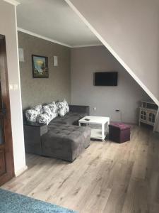een woonkamer met een bank en een tv bij Family Hotel Argo in Varna