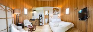 a bedroom with a bed and a table and a tv at Coup 2 Foudres in Saint-Jean-de-Blaignac