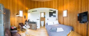 a bedroom with a bed and a tv and wooden walls at Coup 2 Foudres in Saint-Jean-de-Blaignac