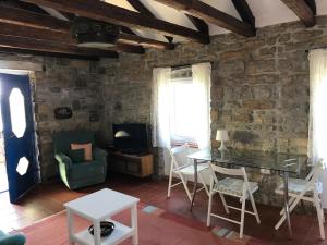 a living room with a stone wall and a table and chairs at Istrian House in Portorož