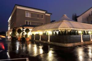 ein Gebäude mit Lichtern auf einem Parkplatz in der Nacht in der Unterkunft BIVIUS Hotel Restaurant Luxembourg in Luxemburg (Stadt)