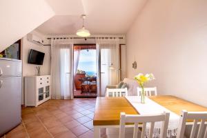 una cucina e una sala da pranzo con tavolo e sedie di Villa Brezza Marina a Nebida