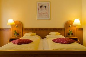 Un dormitorio con dos camas con almohadas rojas y blancas. en Gästehaus Vinetum, en Altdorf