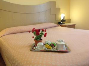 a tray of food and flowers on a bed at Hotel Giovanna in Pompei +46 photos