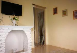 a living room with a fireplace with a flat screen tv at View Dao Jantra in Ban Nok Khao