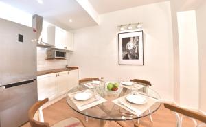 une cuisine et une salle à manger avec une table et des chaises en verre dans l'établissement ABAL Apartments - Teatro, à Alicante