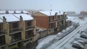una ciudad cubierta de nieve con edificios y coches en A casa con Stefania, en Settecamini
