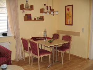 ノルダーナイにあるStrandfliederのテーブルと椅子が備わる客室です。