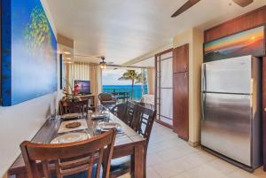 a dining room with a table and a refrigerator at Mana Kai 611C in Wailea