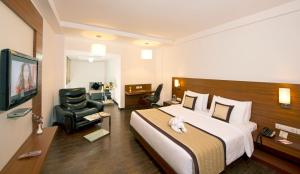 a hotel room with a bed and a chair at Hotel Sandy's Tower in Bhubaneshwar