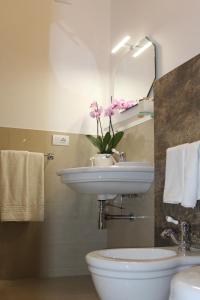 a bathroom with a sink and a vase of flowers at B&B Palazzo Rochira in Castellaneta