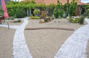 a garden with a brick walkway in front of a house at Dom Pod Zvezdopadom Guest House in Koktebel