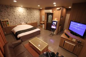 a bedroom with a bed and a flat screen tv at Hotel Sindbad Yamagata (Adult Only) in Higashine