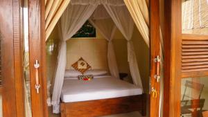 a small bed in a room with a window at Rumahku Homestay in Amed
