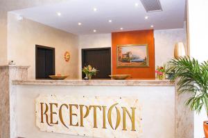 a reception desk with a sign that reads reservation at Hotel La Toscana Nähe Europapark in Ringsheim