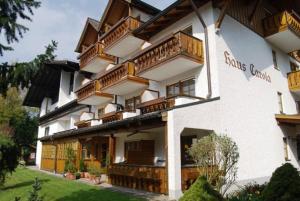 un gran edificio blanco con balcones de madera. en Haus Carola, en Bad Füssing