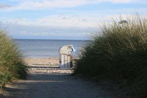 シャルボイツにあるHaus Antjeの海辺の砂浜に座るビーチチェア