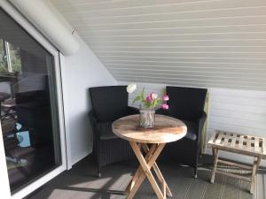 a table with a vase of flowers on a porch at Haus Antje in Scharbeutz
