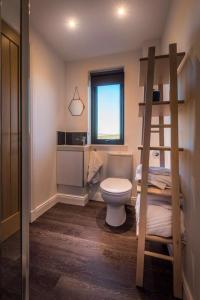 a bathroom with a toilet and a bunk bed at Elfin Cottage in Portree