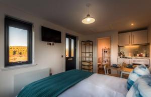 a bedroom with a large bed and a kitchen at Elfin Cottage in Portree
