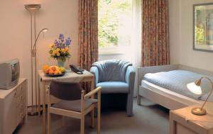 a small bedroom with a bed and a table with a bowl of fruit at Moorland Hotel am Senkelteich in Vlotho