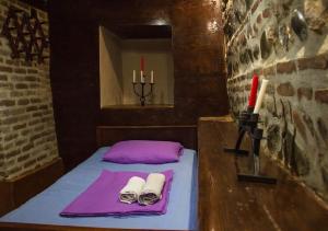 a small bed with two towels and two candles at Feel Old Tbilisi in Tbilisi City +25 photos