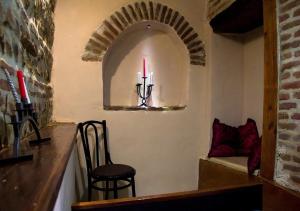 a room with a chair and a candle on a wall at Feel Old Tbilisi in Tbilisi City