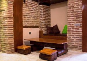 a table and bench in a room with a brick wall at Feel Old Tbilisi in Tbilisi City