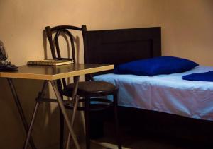 a desk with a chair next to a bed at Feel Old Tbilisi in Tbilisi City