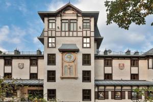 a building with a clock on the side of it at Retro Riverside Wellness Resort in Karlovy Vary