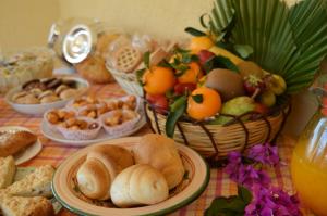 a table topped with plates of food and a basket of fruit at B&B Serenity in Castelluzzo