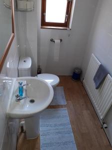 La salle de bains est pourvue d'un lavabo blanc et de toilettes. dans l'établissement Mirandas Guest House, à Berwick-upon-Tweed