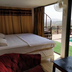 a bedroom with a bed and a balcony at Villa No: 214, Dr.Wade's Villa. in Mumbai