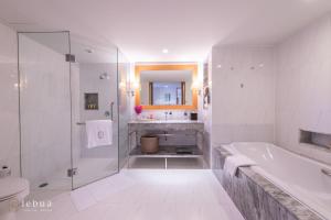 a white bathroom with a tub and a sink at Tower Club at lebua in Bangkok
