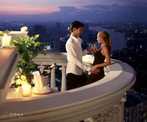 a man and a woman standing on top of a building at Tower Club at lebua in Bangkok